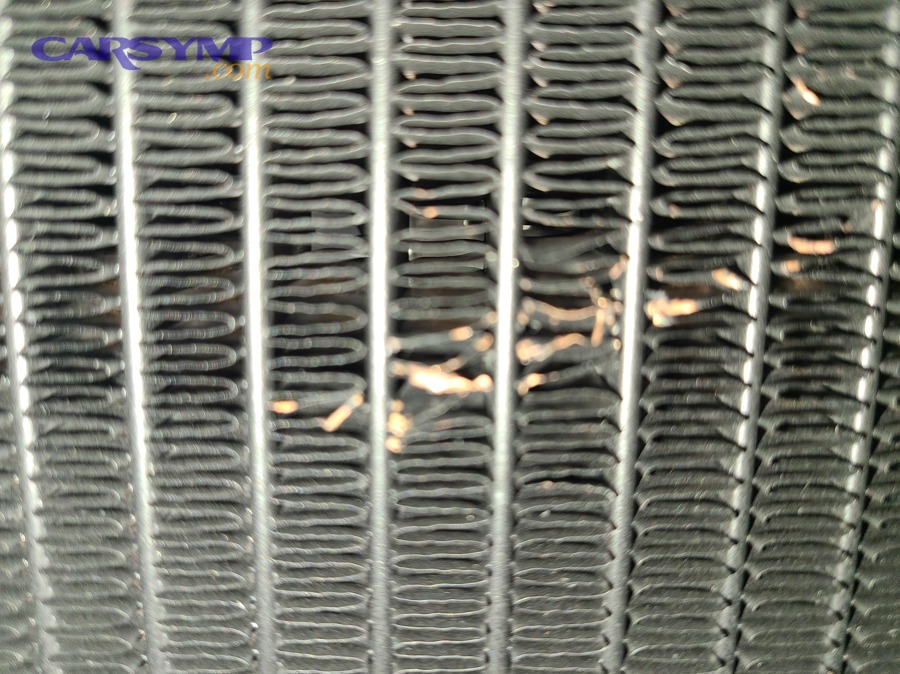 What symptoms suggest an internal condenser leak instead of fin damage?