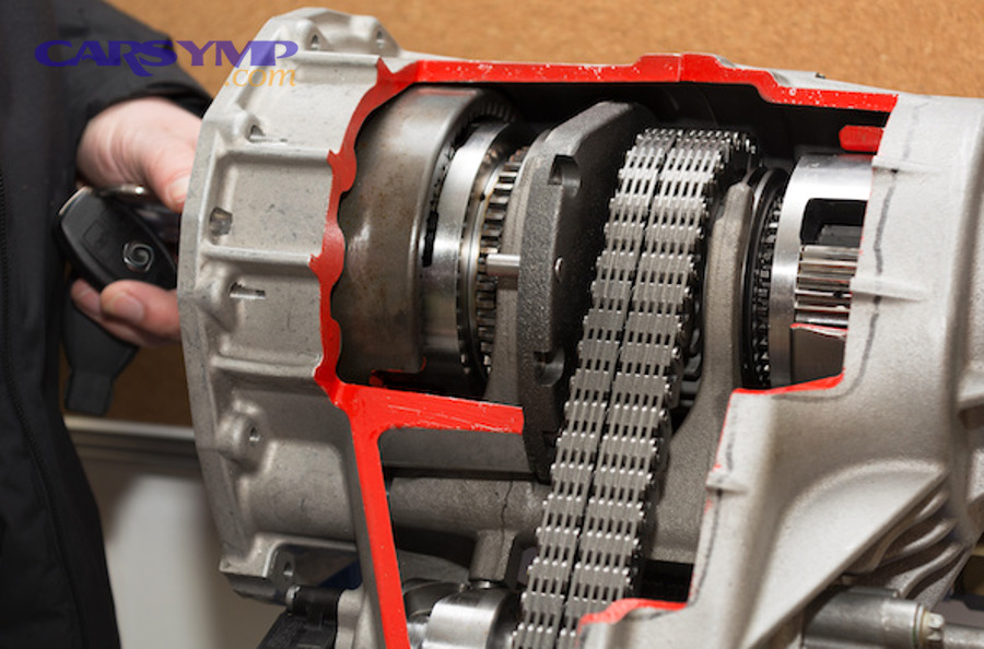 Technician pointing to transfer case fill plug location under a 4WD vehicle