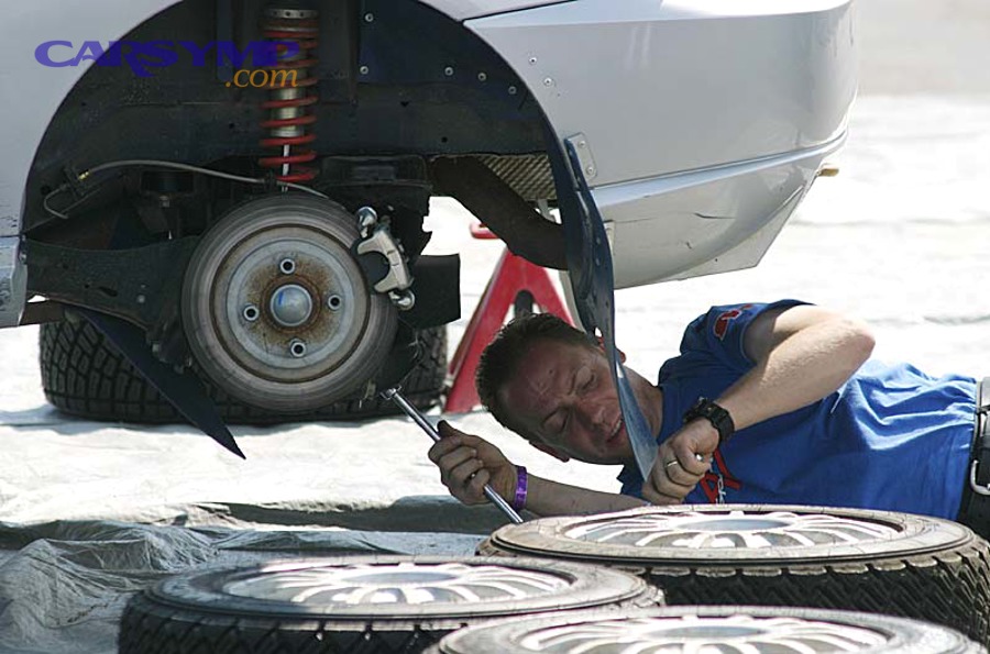 Auto mechanic working on a vehicle with wheels removed during service