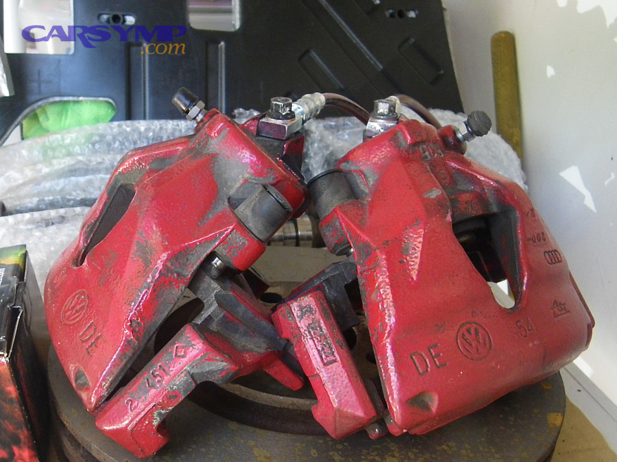 Where does a caliper-area leak usually show up, and what confirms it?