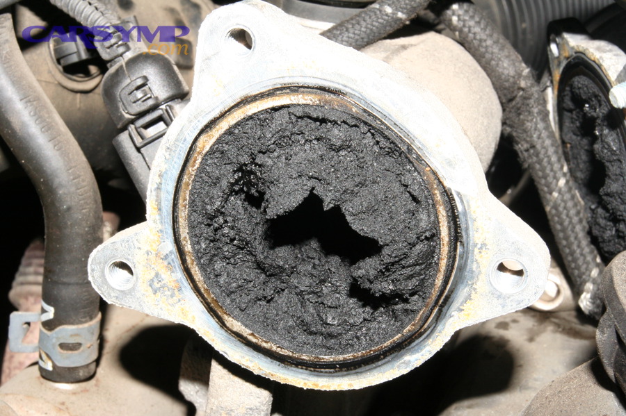 Clogged EGR valve and intake manifold showing heavy soot buildup