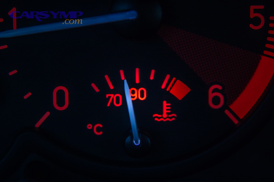 Close-up of a car temperature gauge with needle near the hot warning area