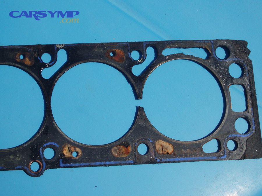 Damaged head gasket showing a failed sealing area between cylinders