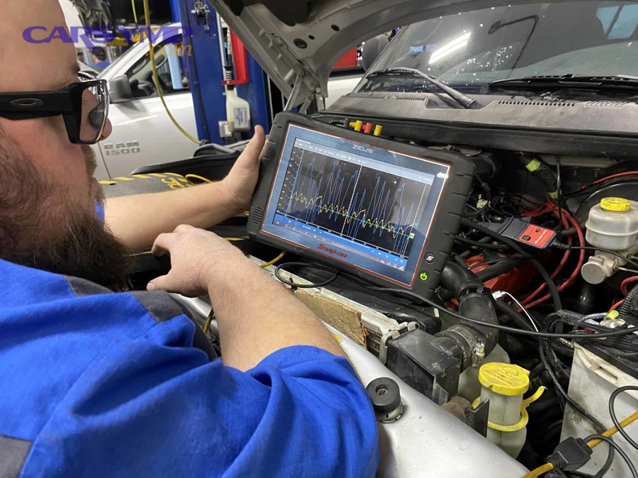 Technician performing electronic automotive system diagnostics