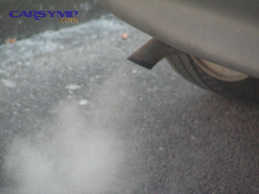 Exhaust steam visible near a tailpipe in cold conditions