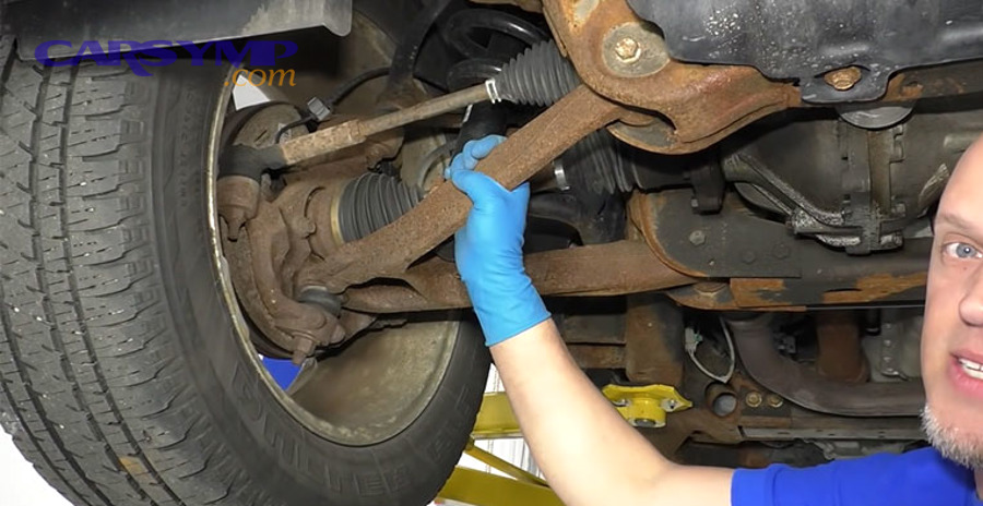How do you check ball joint play at home versus at a shop?