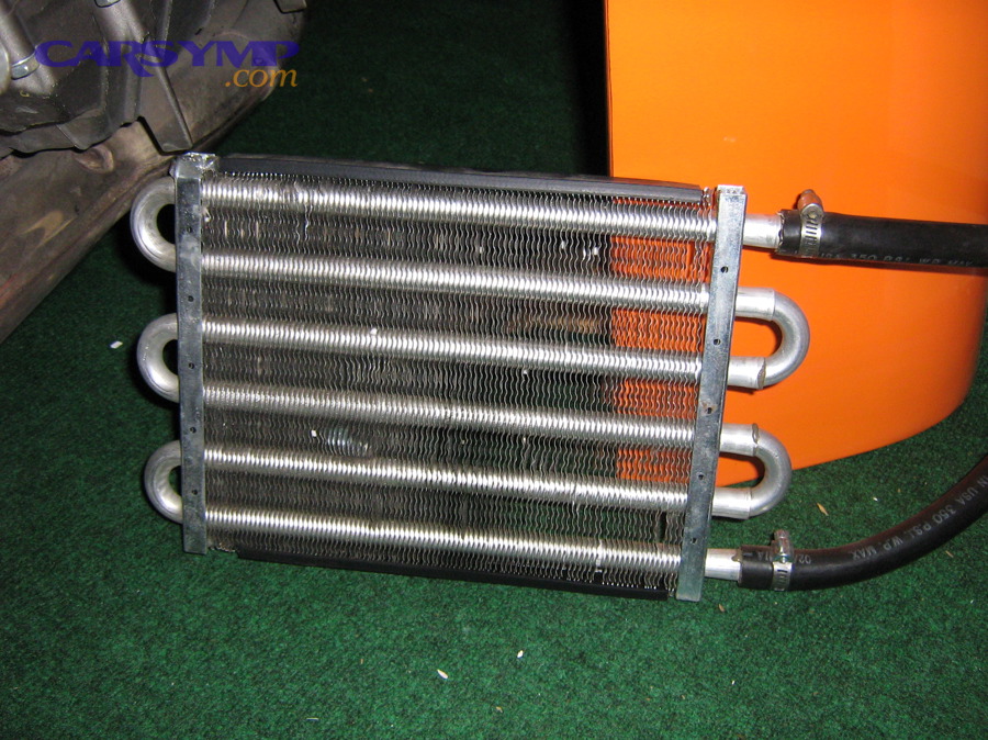 External oil cooler showing fins and hose connections