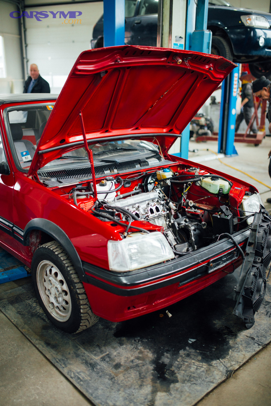Car with open hood in an auto repair shop during evaluation