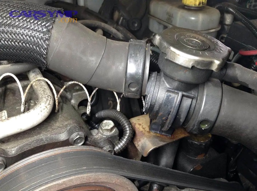 Mechanic inspecting engine bay for leaks and residue