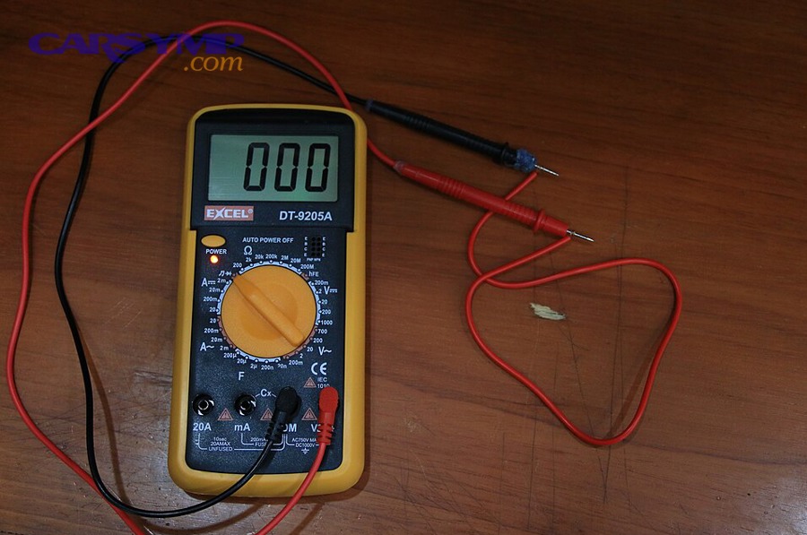 Multimeter with probes set up for electrical testing on a bench