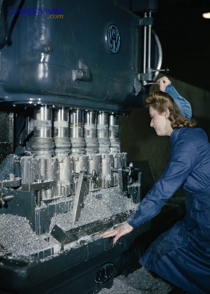 A woman war worker machining a cylinder block for a Rolls Royce aero engine. TR1