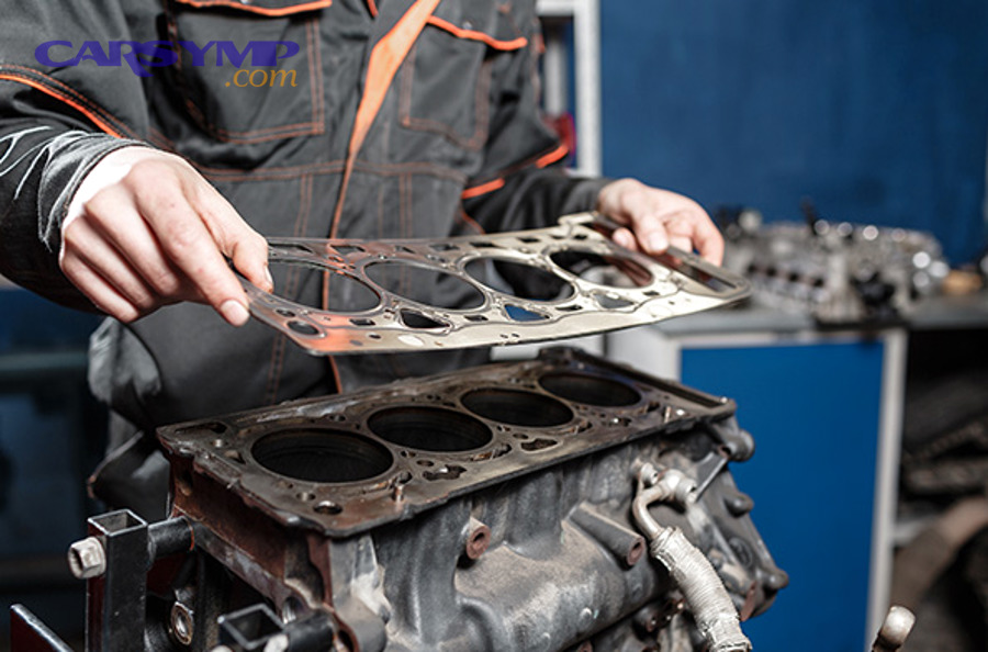 Head gasket replacement illustration showing gasket positioned between engine block and cylinder head
