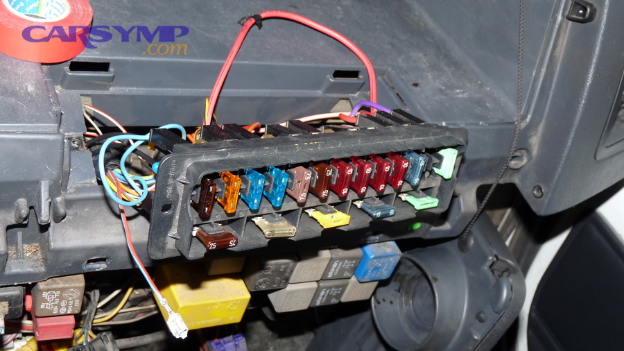 Vehicle fuse box with blade fuses and relays visible