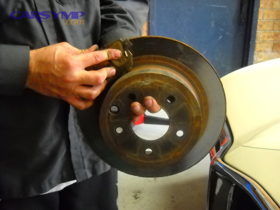 Brake pads being shown during inspection (example of checking pad condition)
