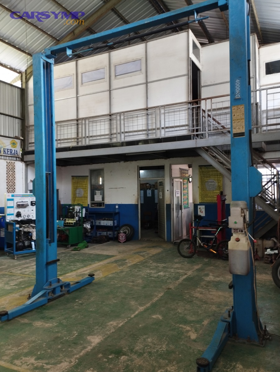 Car lift in a workshop, representing shop overhead behind labor rates