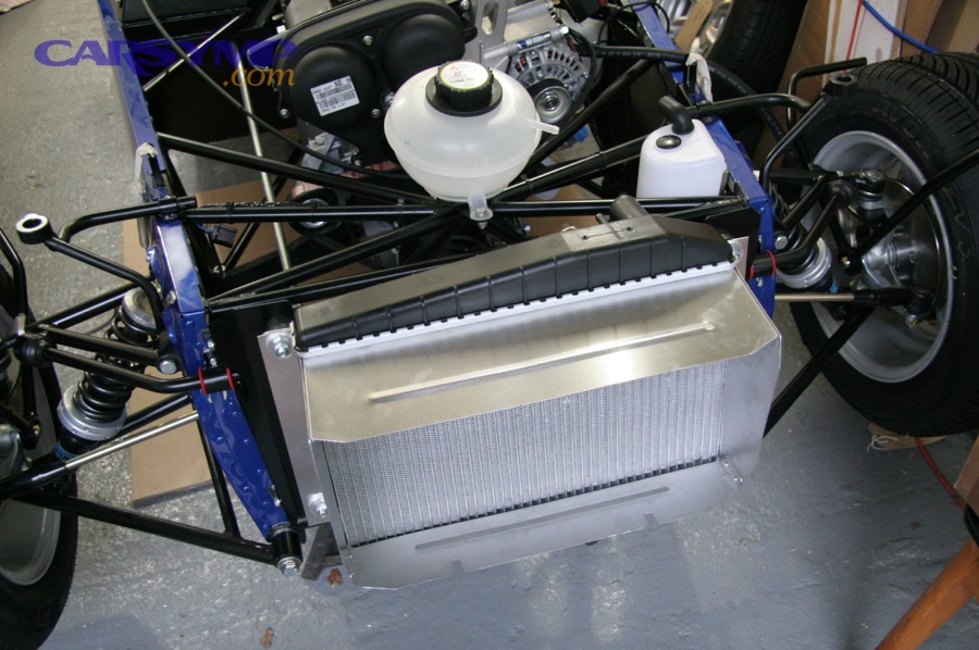 Coolant expansion tank in an engine bay used to check coolant level between marks