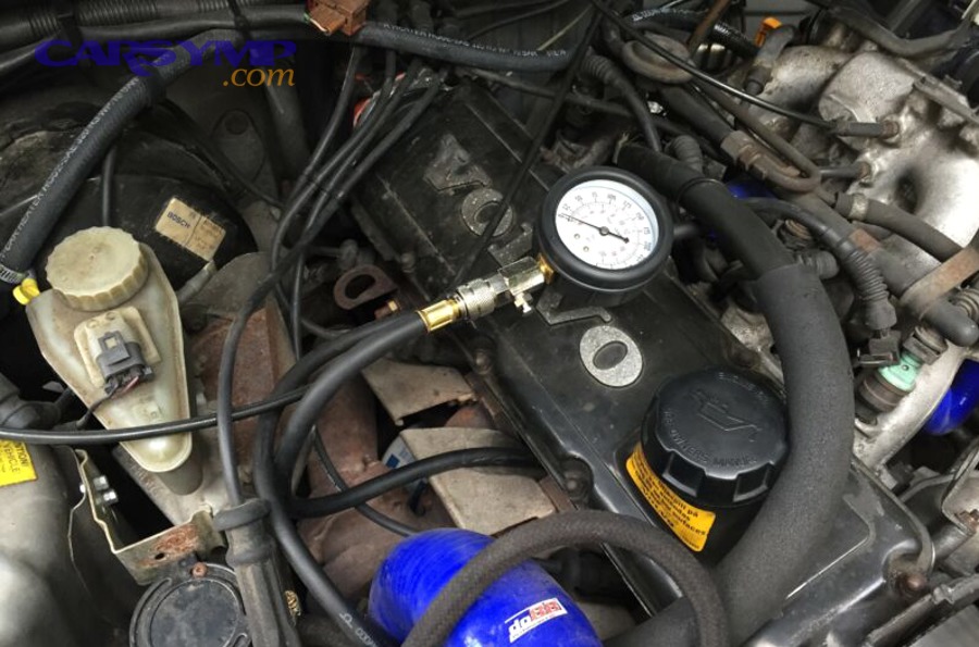 Compression test gauge connected to an engine for diagnosing misfires