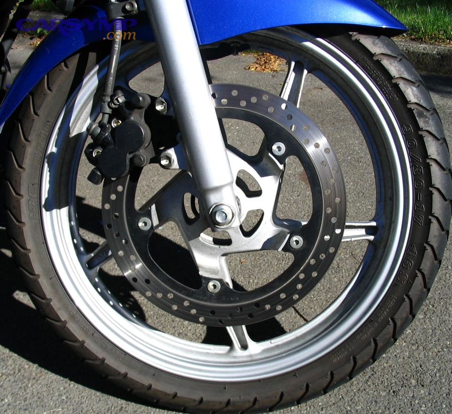 Disc brake on a motorcycle illustrating pad-to-rotor contact that can squeal or grind