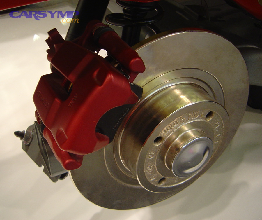Disc brake rotor and caliper close-up where grinding can occur if pads are worn or debris is trapped