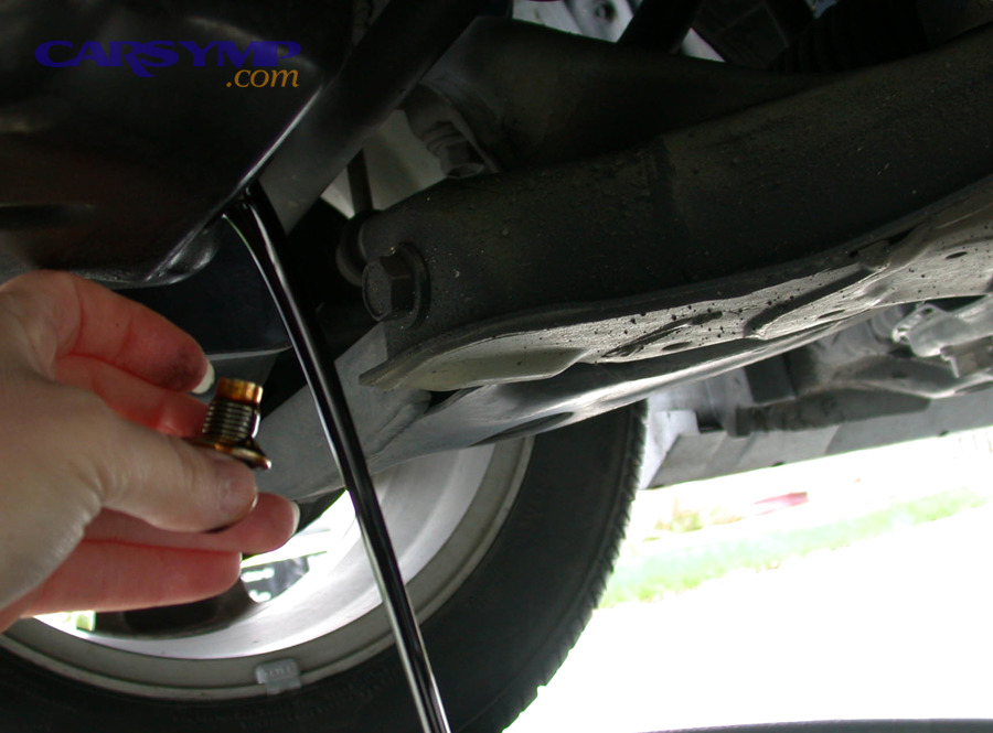 Draining motor oil from a vehicle underneath the car