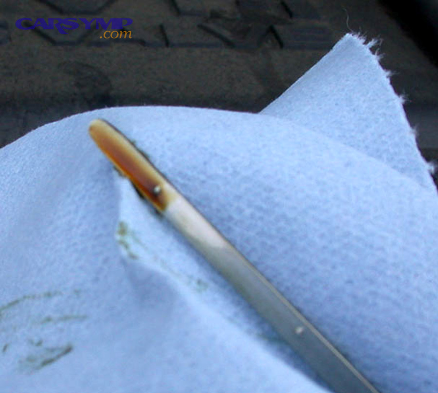 Reading oil level on a dipstick between minimum and maximum marks