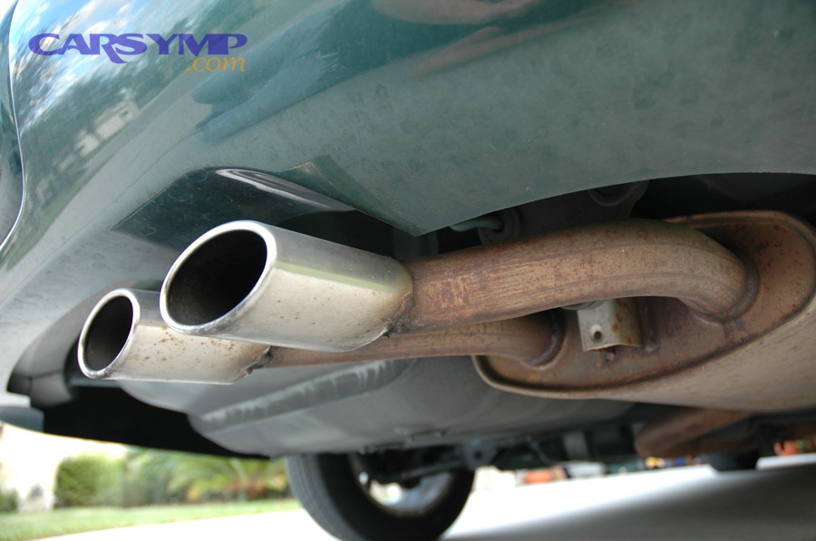 Car exhaust piping underneath vehicle showing typical exhaust routing