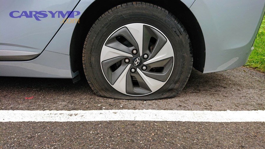 A damaged automobile tire that has gone flat
