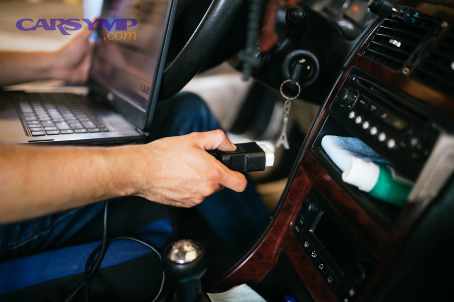OBD2 diagnostic connector being held near a car for scanning