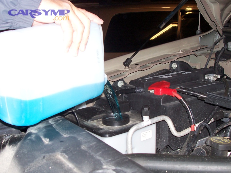 Pouring windshield washer fluid into a vehicle reservoir