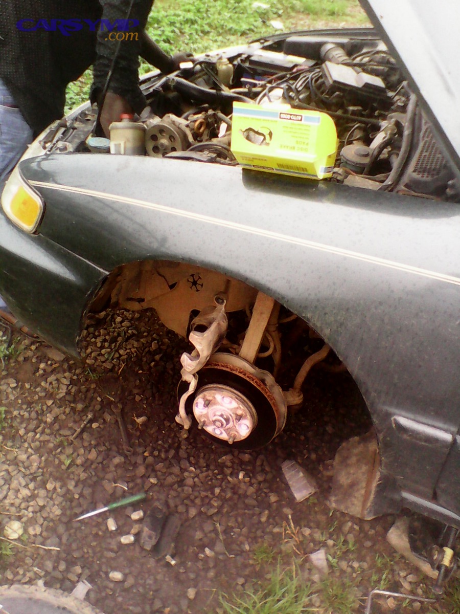 Mechanic working on brake pads, illustrating fully burdened labor rate costs