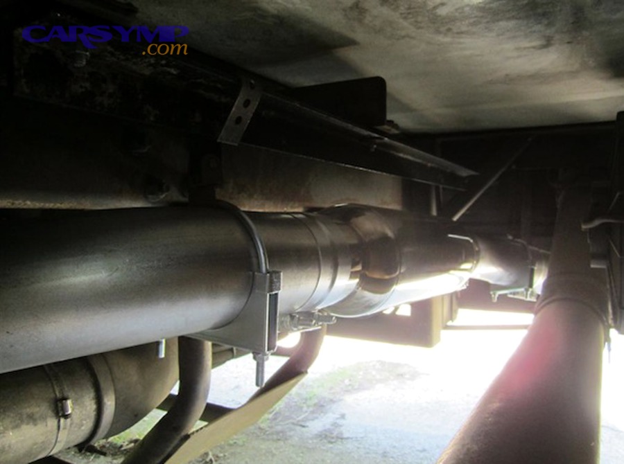 close up of damaged exhaust resonator showing rust and holes