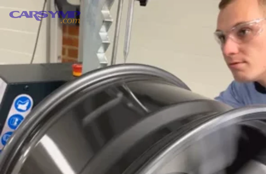 technician applying controlled heat to bent wheel rim section during straightening repair