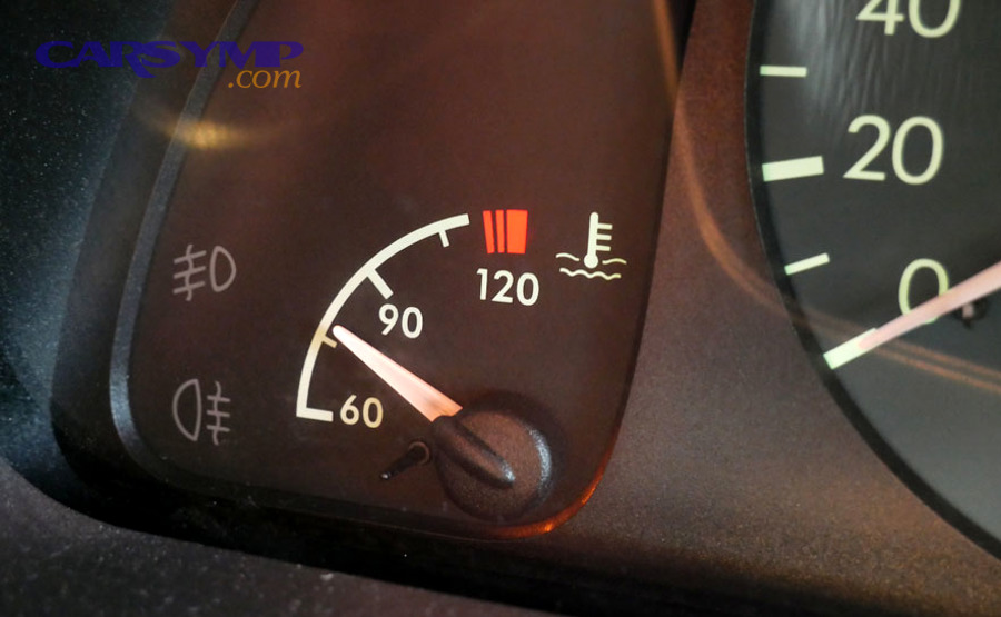 mechanic checking lower radiator hose temperature for coolant flow