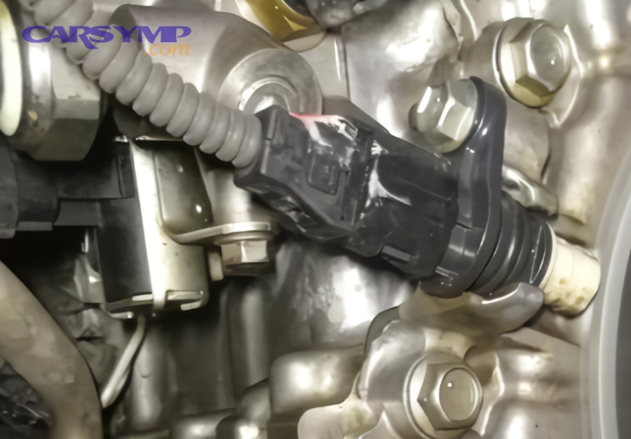 Mechanic holding a crankshaft position sensor during diagnosis