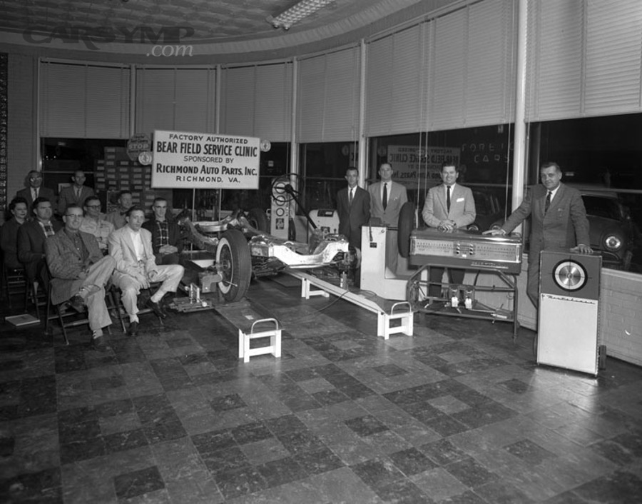 Mechanics working on wheel alignment equipment during a clinic demonstration