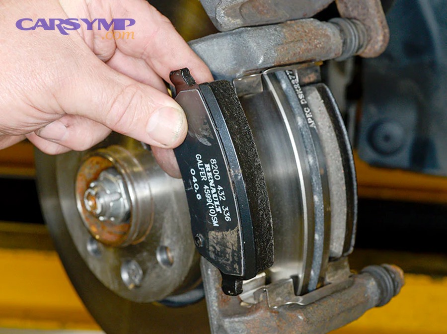 Mechanic compressing brake caliper piston with specialized tool