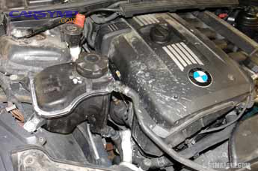 Coolant expansion tank residue and leak signs in engine bay