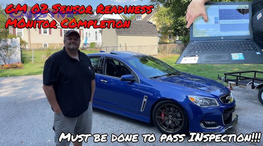 Handheld OBD2 scanner showing readiness monitor status colors (ready vs not ready)