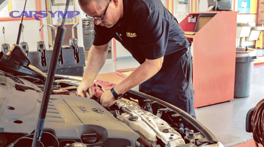 Technician performing routine vehicle service in a garage