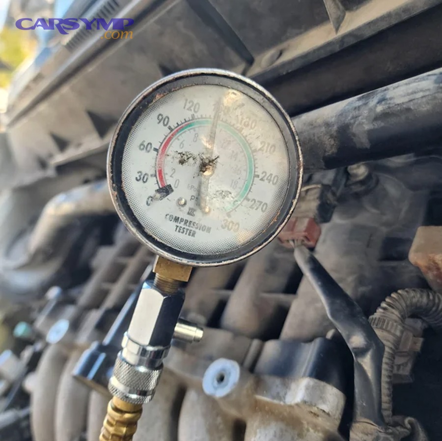 Cylinder leak-down tester connected to an engine to pinpoint where compression is leaking