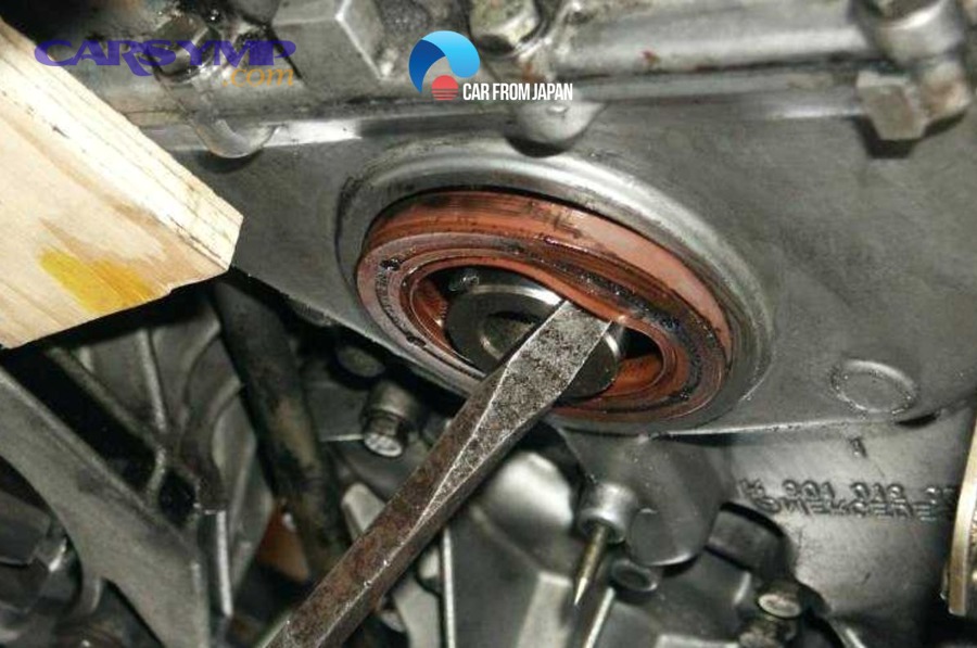 checking engine oil dipstick showing low oil level from rear main seal leak