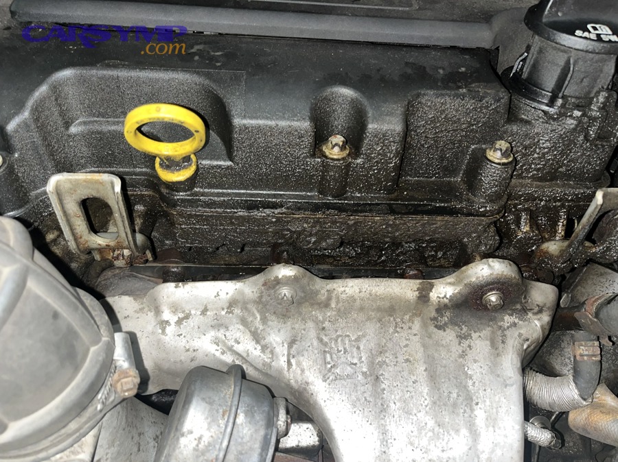 Valve cover gasket replacement work being performed on a car engine