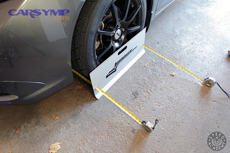 Driver performing a basic DIY check before professional wheel alignment