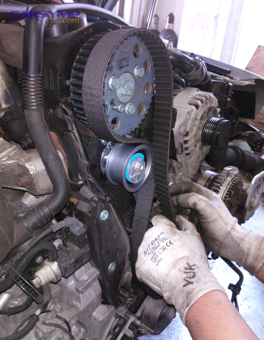 Mechanic replacing a timing belt during engine service