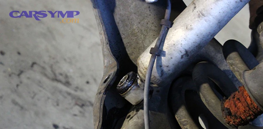 Mechanic inspecting shock absorber for leaks and physical damage during vehicle maintenance