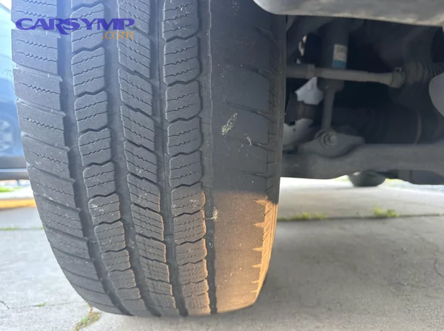 Driver checking tire pressure and tread to identify uneven wear cause