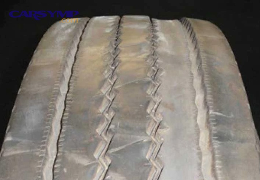 Mechanic deciding whether to replace tires or repair the cause of uneven wear