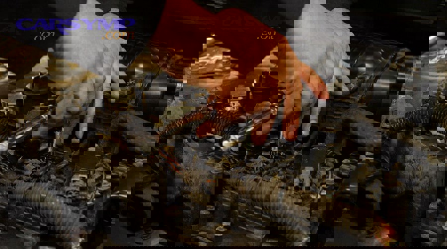 Diagram showing valve cover, spark plug tube seal, and spark plug well