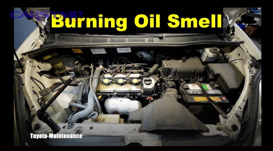 Driver using a flashlight to inspect the valve cover area for oil leaks