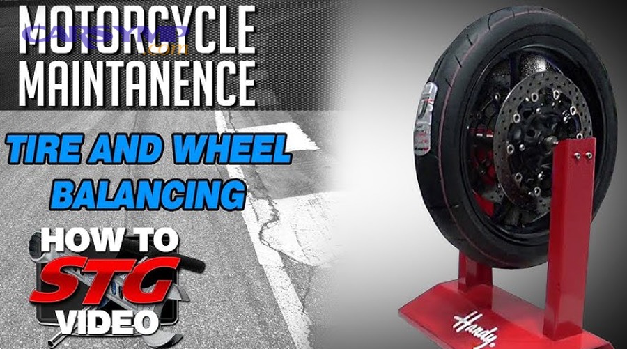Technician performing wheel balancing service on a tire and wheel assembly